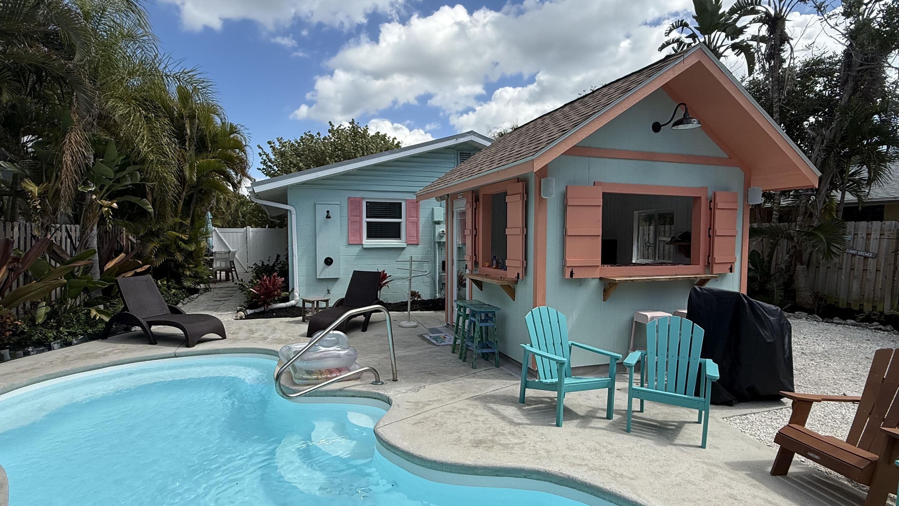 The private pool and the coral-shuttered outdoor bar pavilion in the cottage's fenced tropical backyard