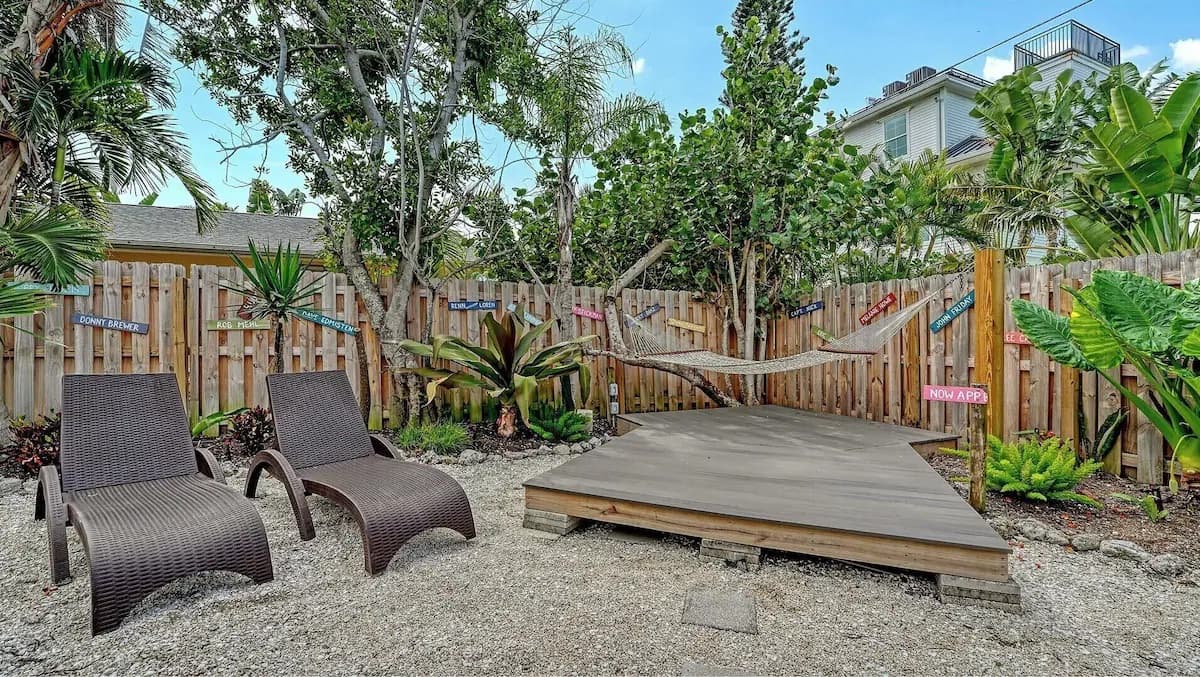 Two loungers beside the wooden hammock landing in the backyard garden